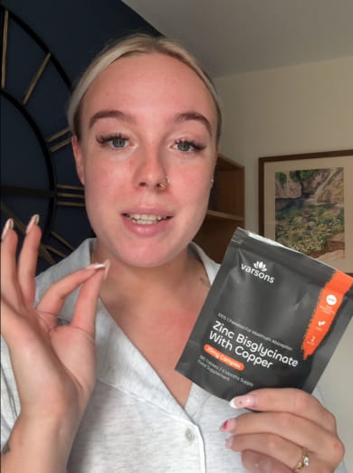 Customer talking to camera while holding a Varsons Zinc Bisglycinate with Copper pouch