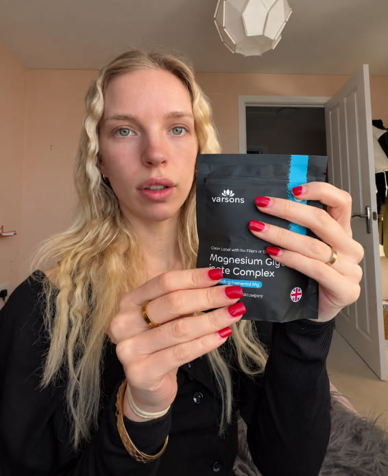Customer holding up a pouch of Varsons Magnesium Glycinate 3 in 1 Complex
